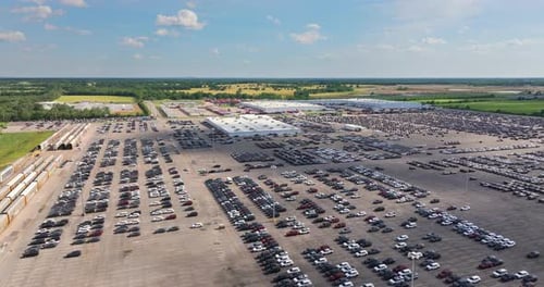 Parked New Cars at the Automotive Plant Factory Parking Lot Ready for Sale Development of American