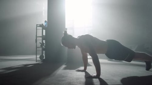 Muscular man doing push ups during fitness session at sport club for strength training
