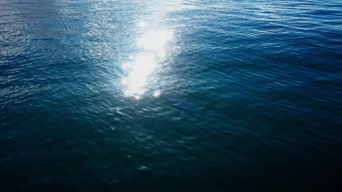 Luftaufnahme von oben auf ein transparentes blaues Meer mit schönen Wellen an sonnigen Tagen im Sommer. Meeresluft