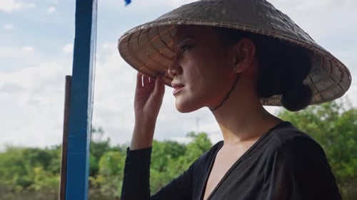 Woman in Conical Hat Travels Southeast Asia by Boat