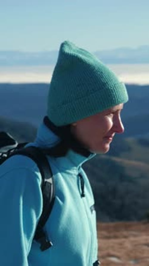 Female hiking along mountain range, enjoying amazing nature. Vertical video