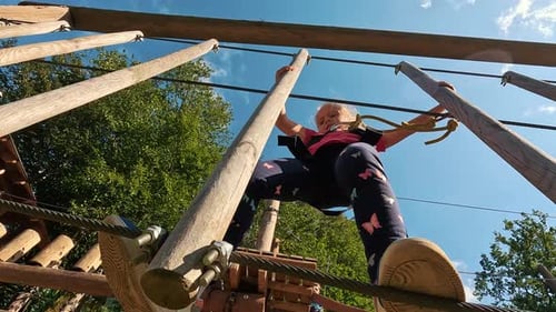 Happy Little Girl Playing in Tarzan Attraction on Playground in Amusement Park. Little Girls Enjoy P