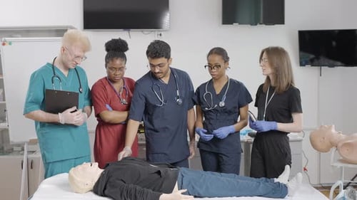 Medical students with instructor practicing first aid in clinic