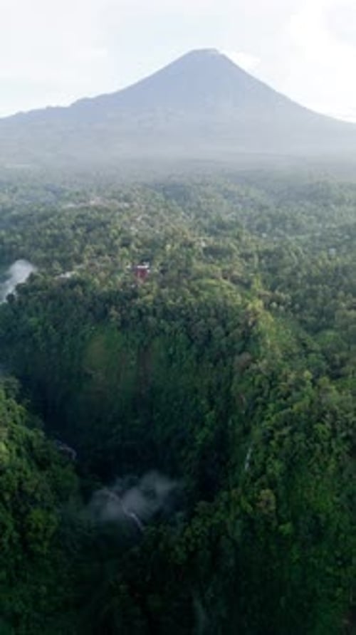 Drone en orbite cinématographique filmé au-dessus du canyon de Tumpak Sewu avec le mont Semeru