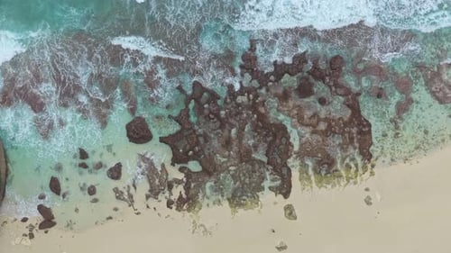 Vue aérienne de haut en bas des vagues de l'océan s'écrasant sur une plage tropicale