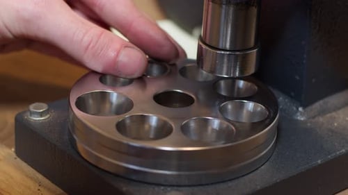 Juwelier presst in seiner Werkstatt einen Goldring ein