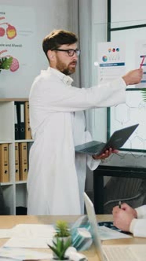 Scientist with Laptop Explaining Data at Presentation