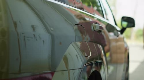 Nahaufnahme eines Fahrers, der das Elektrofahrzeug an der EVSE-Station anhält, um es aufzuladen