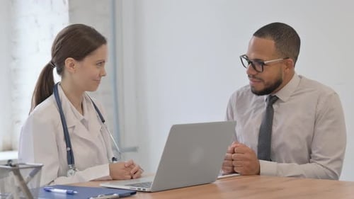 Female Doctor Talking with Patient in Clinic