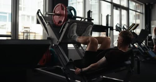 Man Using Leg Press at Modern Gym