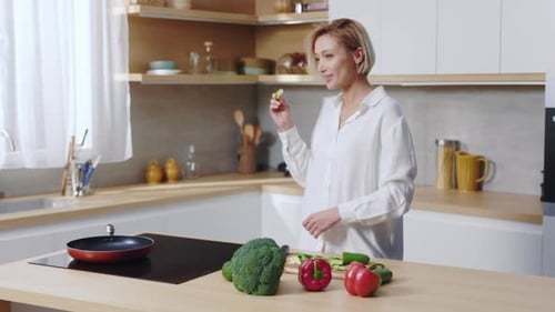 Woman Prepares Vegetables in Kitchen and Dances