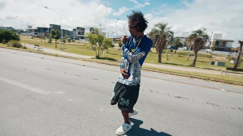 Homem estiloso afro-brasileiro fica na rua com as mãos estendidas
