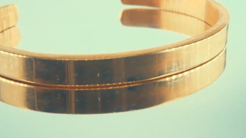 Macro rotating close up shot of a golden bracelet on a 360 stand, 4K