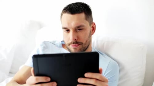 Man in Bed Uses Tablet for Video Call