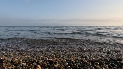 Sea Beach Horizon Sea Waves with Soft Foamy Waters Washing Multicolored Pebbles on a Beach During