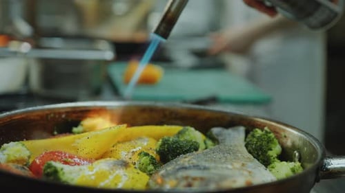 Chef Cooking Fish and Vegetables with Torch