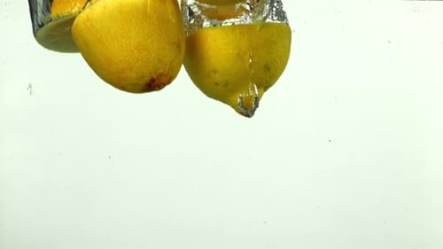 Lemons Falling into Water in Slow Motion