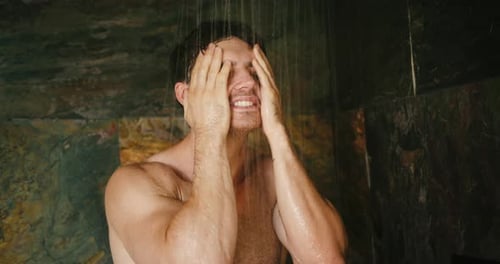 Man Washing Face in Shower With Running Water