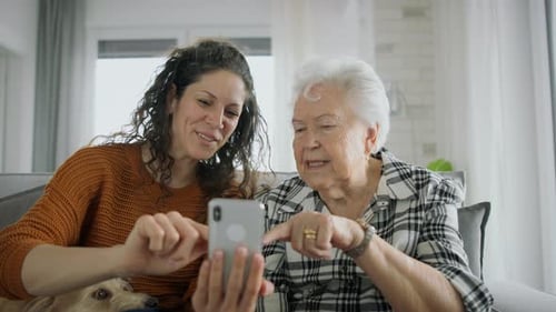 Woman and Senior Woman Laughing at Smartphone