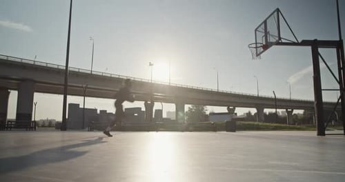 Basketball Player Dribbles and Dunks on Outdoor Court