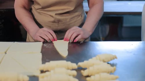 Women's Hands Roll Croissants in a Bakery Making Croissants The Concept of Production of Bakery