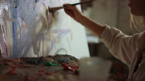 Woman Painting on Canvas with Brush in Studio