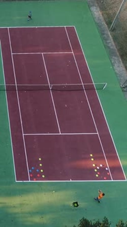 Vertical Video of Two People Playing Tennis on the Tennis Court Aerial View
