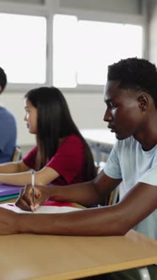 Multiracial Group of Diverse Students Listening Teacher in Classroom