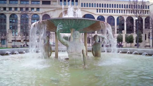 Old roman statue in a water fountain, looking like it's taking a selfie, roman architecture in Montp
