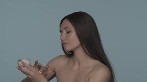 Cream for Skin Care A Seminude Woman Applies Cream to Her Face Woman with a Jar of Cream in Her