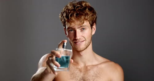 Face, perfume and man in studio, cosmetics and dermatology treatment on gray background