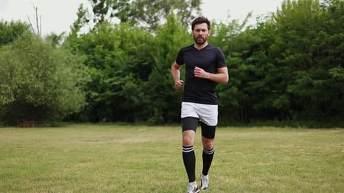 Experienced Runner in Sportswear Getting Traumatised During Jogging at Field