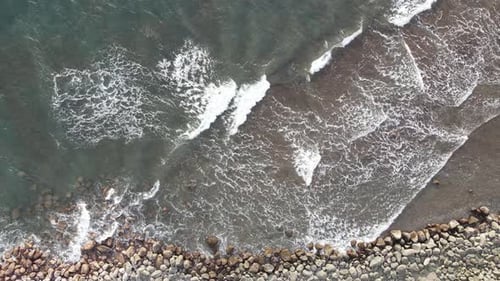 Waves Crashing on Rocky Shoreline from Above