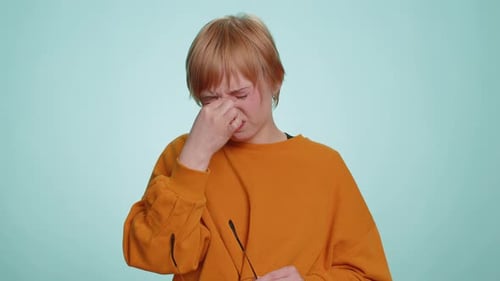 Young Woman Rubbing Eyes in Studio Setting