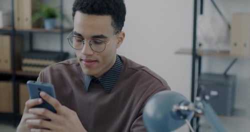 Portrait of Male Employee Using Smartphone Messaging in Office
