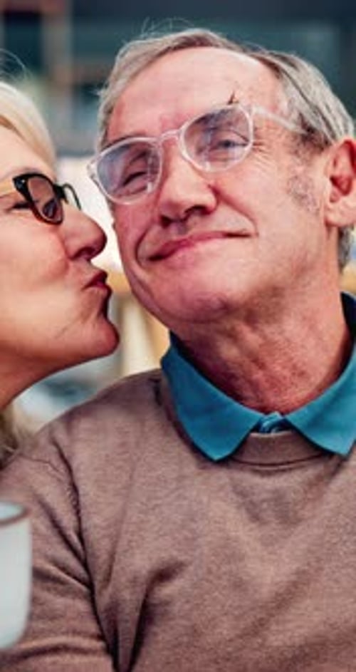 Senior Couple Affectionate Kiss Indoors