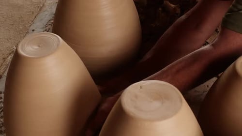 Section médiane d'un potier arrangeant un vase en argile pendant un atelier de nettoyage