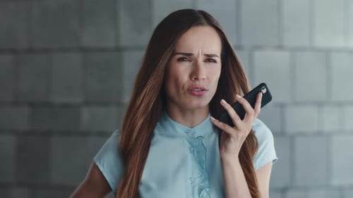 Displeased Businesswoman Recording Voice Message on Cellphone in City. Portrait of Dissappointed