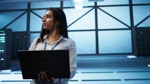 Tracking Shot of Woman in Server Hub Ensuring Networks are Secure