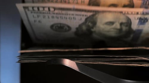 La vista de cerca de la máquina contadora de divisas La máquina contadora calcula billetes de 100 dólares estadounidenses