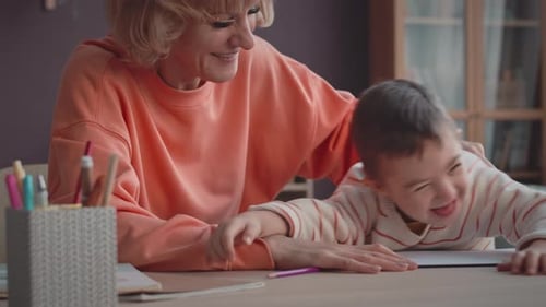 Woman and Child Drawing Together at Table