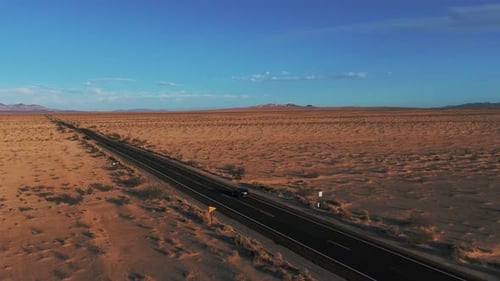 Modern car driving on a street in the desert from California to Arizona. Cinematic sunset landscape.