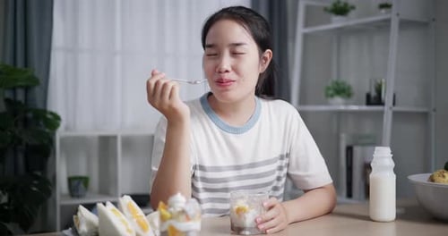 Young Woman Eating Dessert Indoors At Table