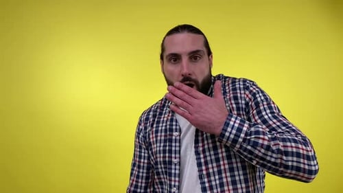 Man Talking and Gesturing Against Yellow Background