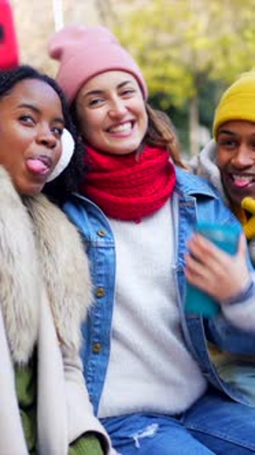 Cheerful Friends Taking Selfies in a Winter City Park