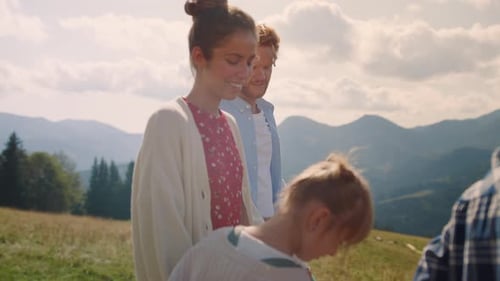 Family walking together on grassy hillside in mountains