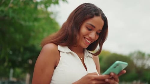 Smiling Woman Using Smartphone Outdoors