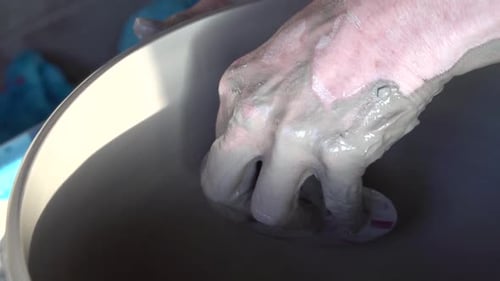 Les mains d'un potier au travail sur une roue.
