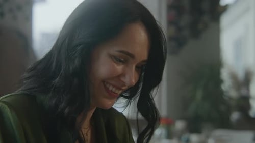 Adult Woman Sits in Modern Cafe Smiles and Talks