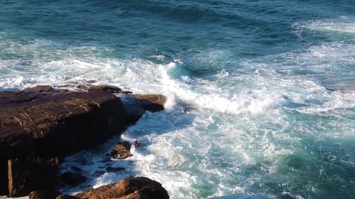 Aerial view of Ocean waves flooding on rocky shore, showing extreme force of ocean. Ultra Slow motio